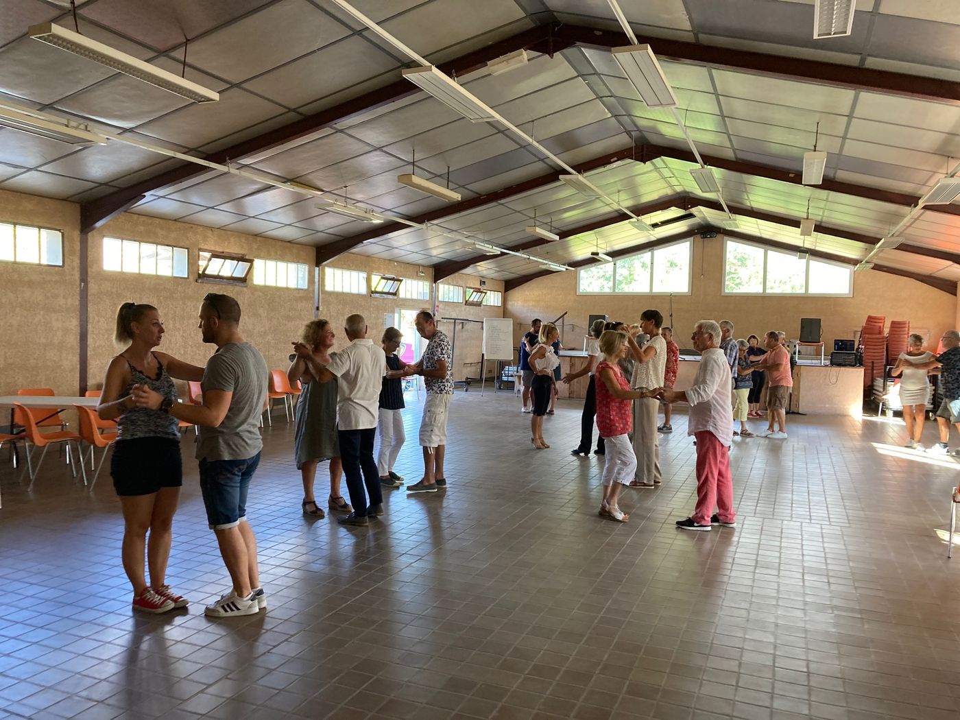 Stage de danse dans une grande salle : des couples dansent sous la charpente