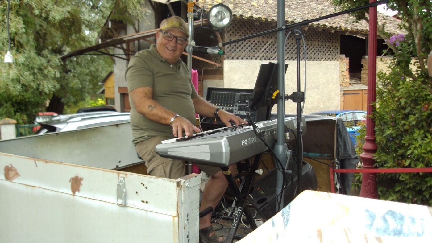 Un musicien souriant joue du clavier en plein air lors d’une scène ouverte